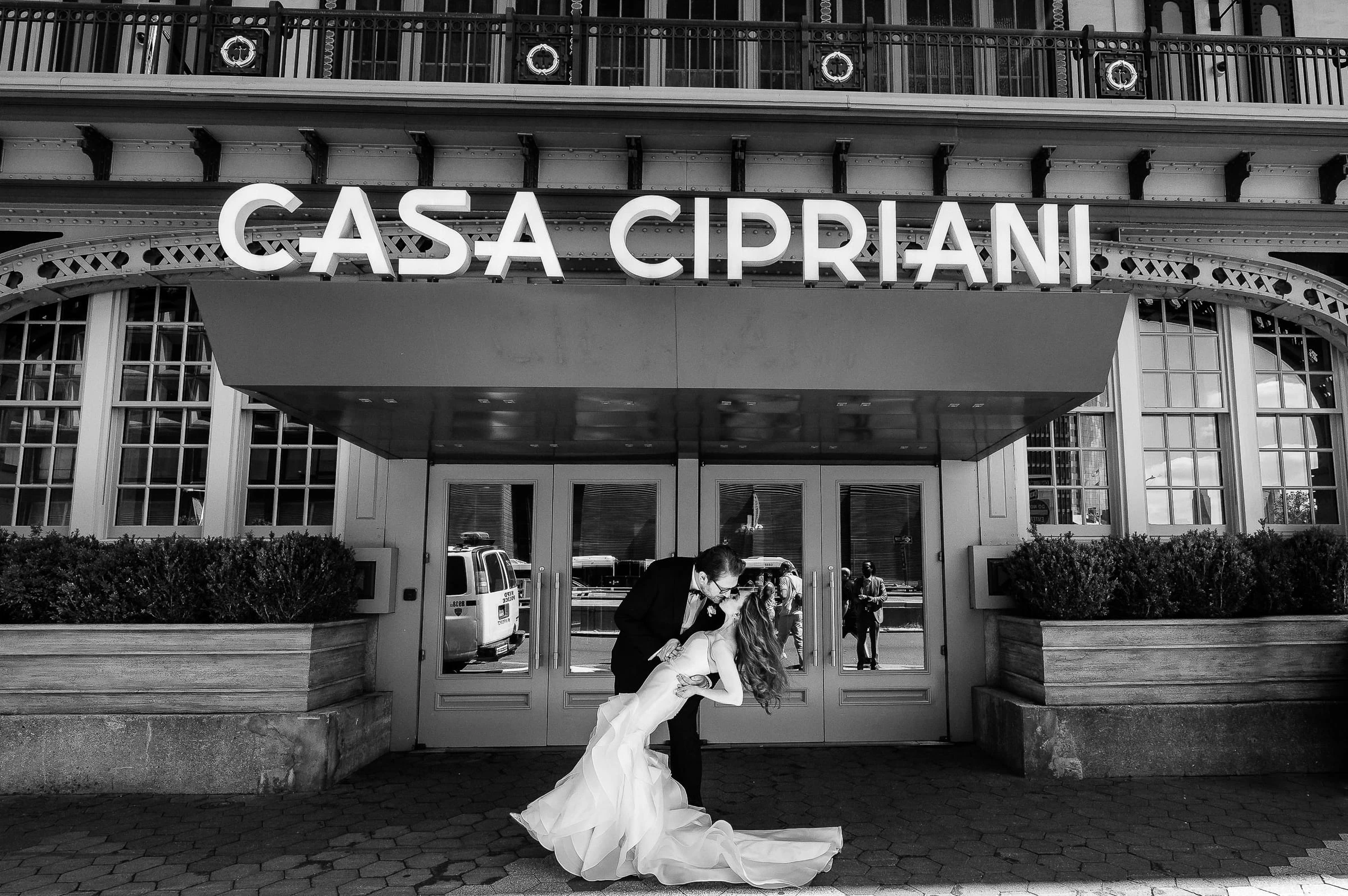 The couple outside beneath the Casa Cipriani sign, in black and white — Casa Cipriani, New York