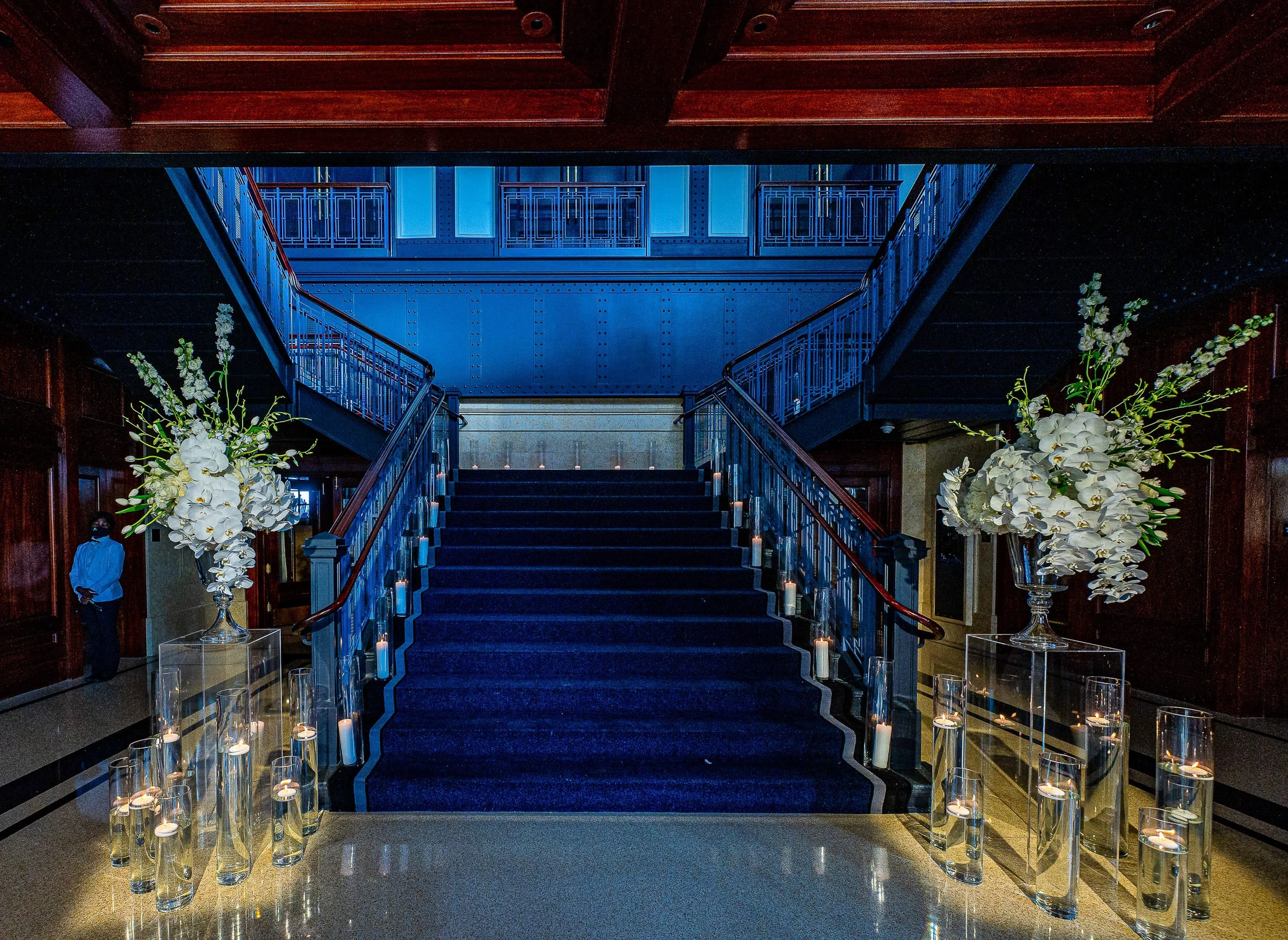 The blue staircase dressed with orchids and candles — Casa Cipriani, New York