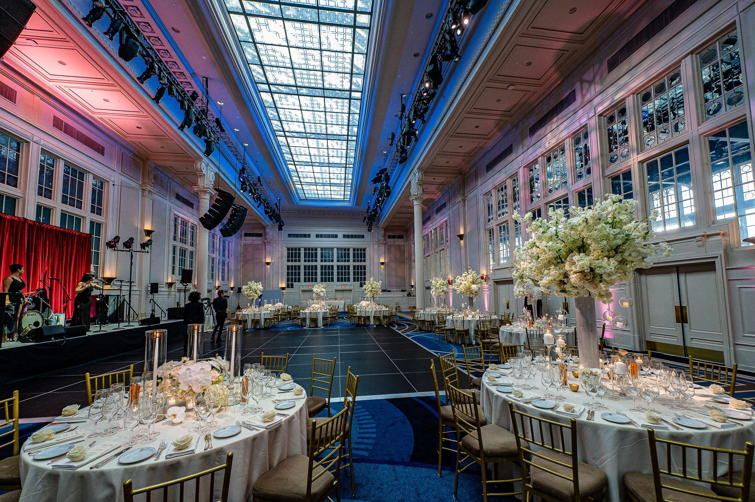 The ballroom set for dinner beneath its skylight — Casa Cipriani, New York