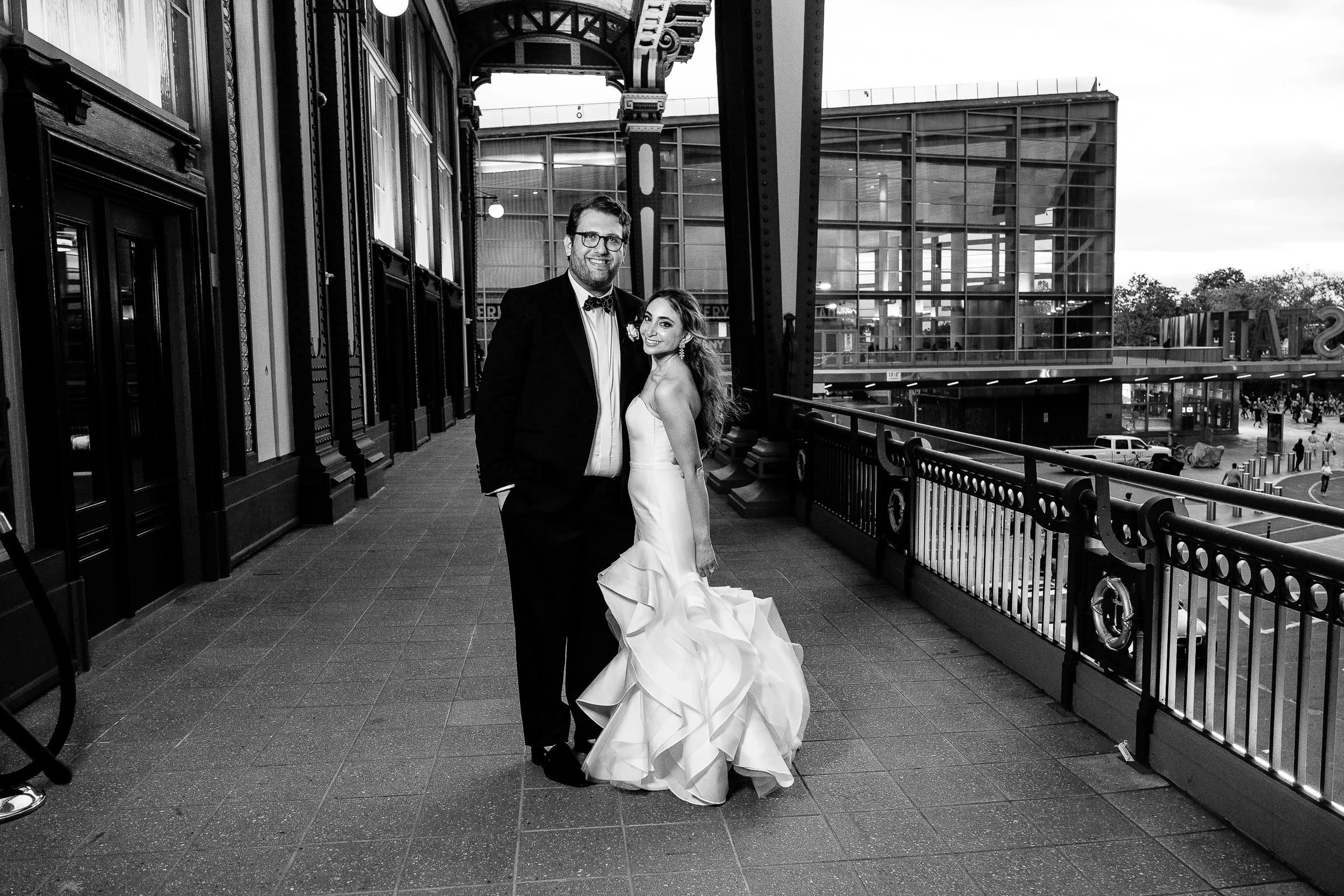 The couple standing together on a terrace beside the railing, in black and white — Casa Cipriani, New York