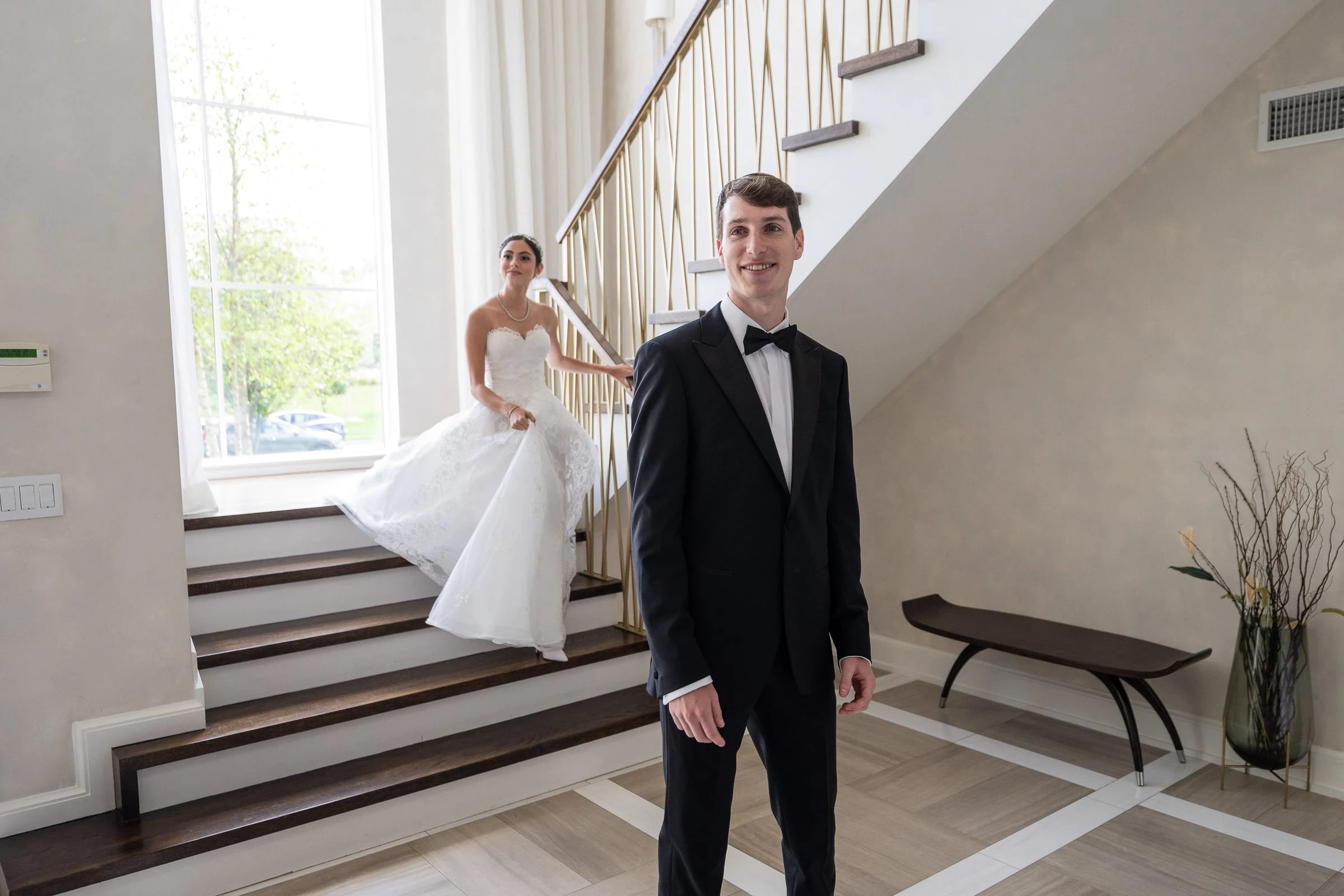 The bride coming down the stairs behind the waiting groom — Shadowbrook at Shrewsbury, Shrewsbury