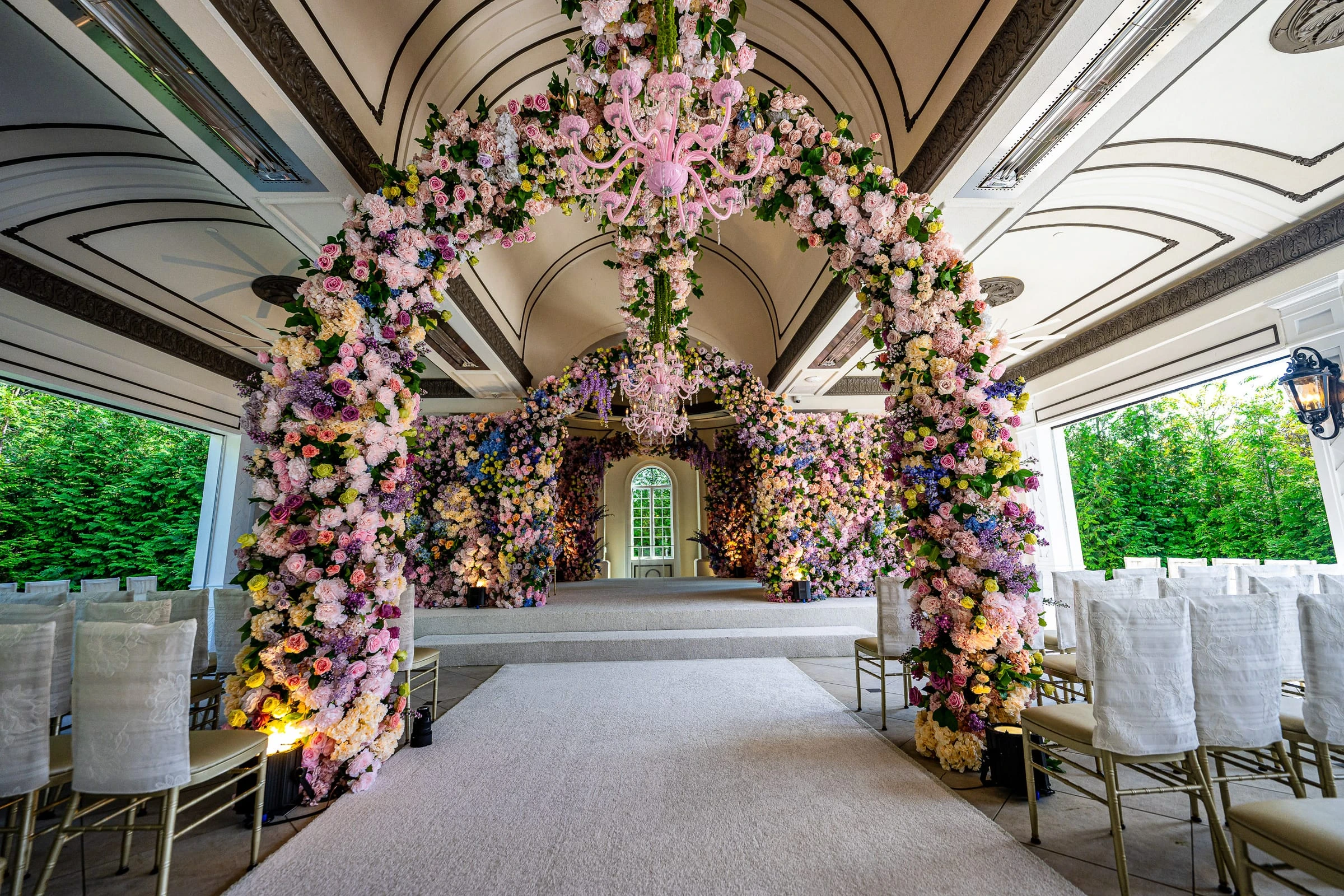 The ceremony room built out of flowers beneath a pink chandelier — Shadowbrook at Shrewsbury, Shrewsbury