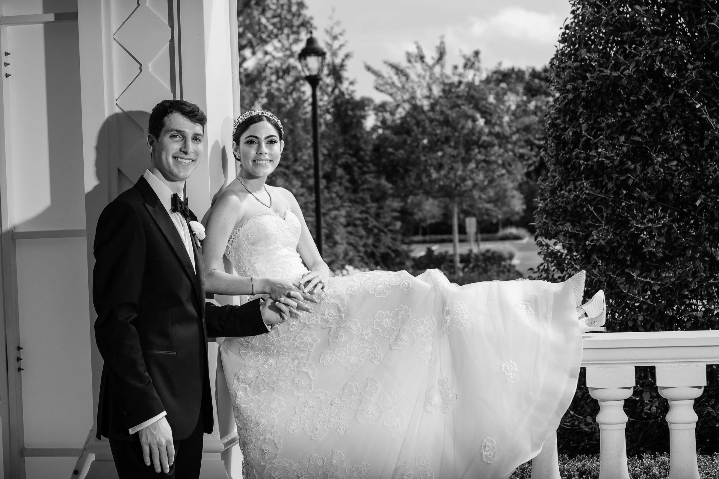 The couple outside with her gown spread across the balustrade, in black and white — Shadowbrook at Shrewsbury, Shrewsbury
