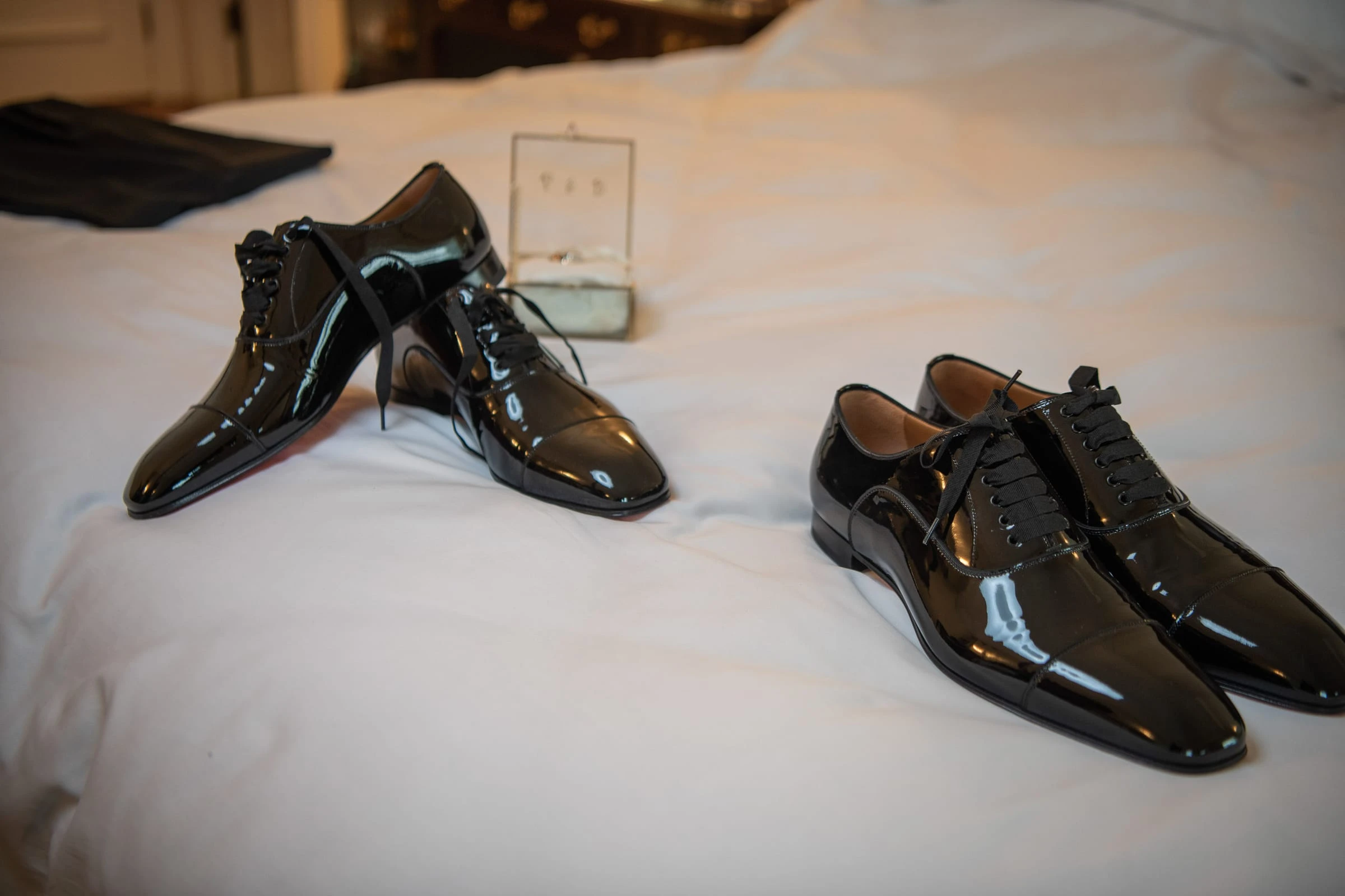 Two pairs of patent shoes waiting on the bed — Metropolitan Club, New York