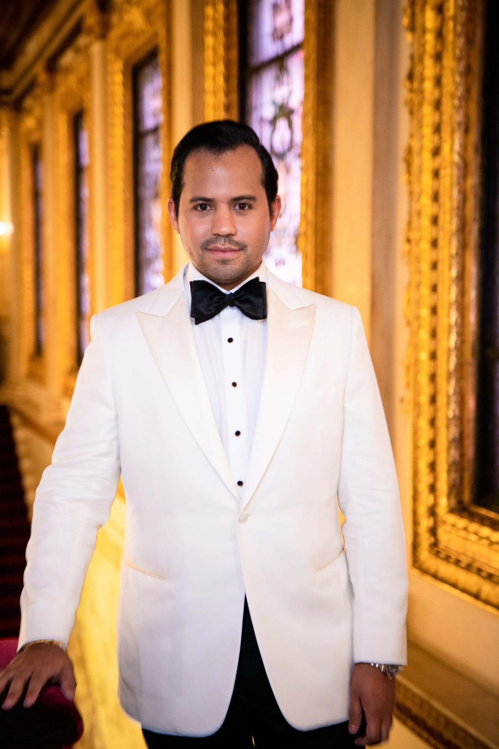 The other groom in his white dinner jacket by the stained glass — Metropolitan Club, New York