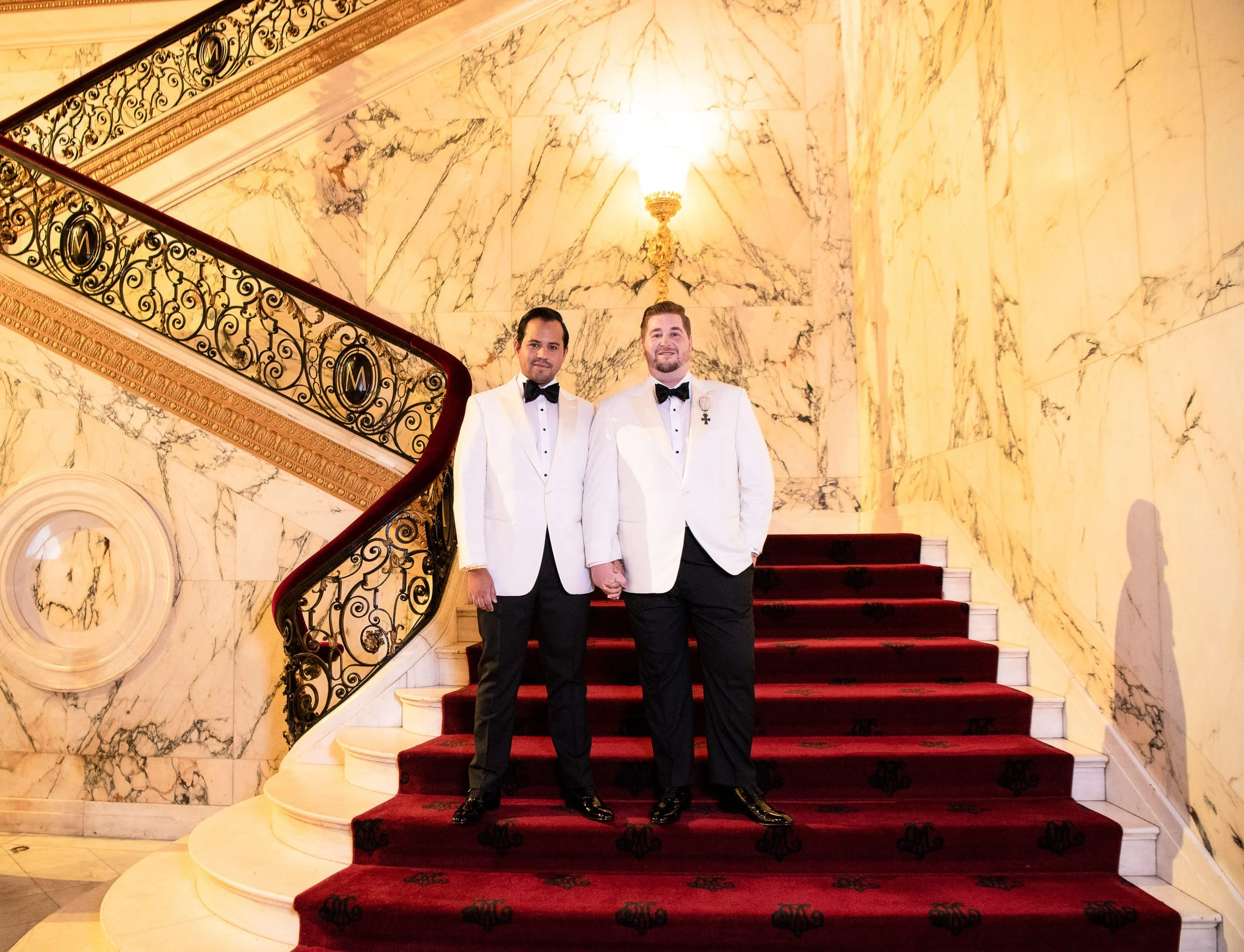 The two grooms on the red-carpeted marble staircase — Metropolitan Club, New York