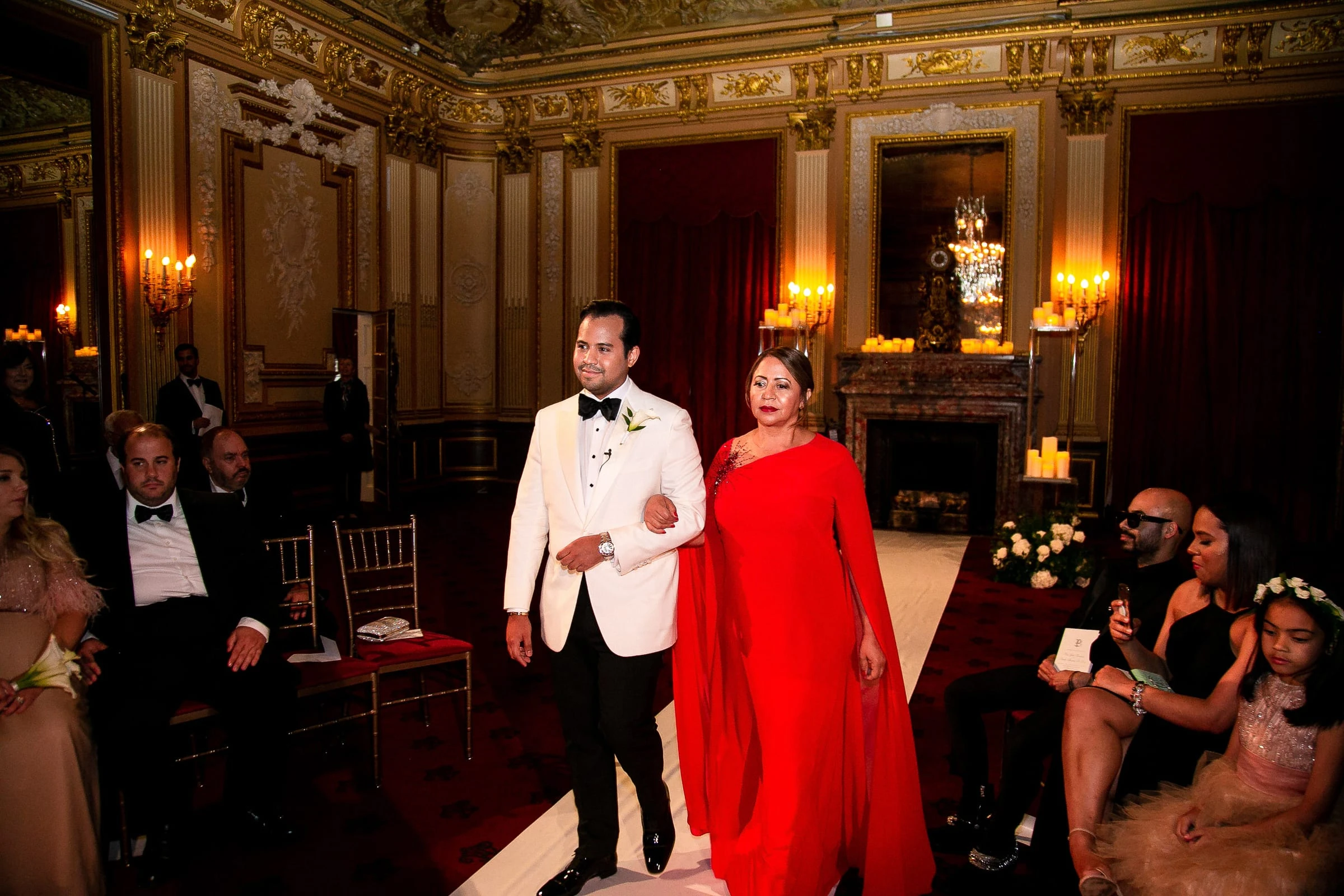 A groom entering the aisle arm in arm with a woman in red — Metropolitan Club, New York