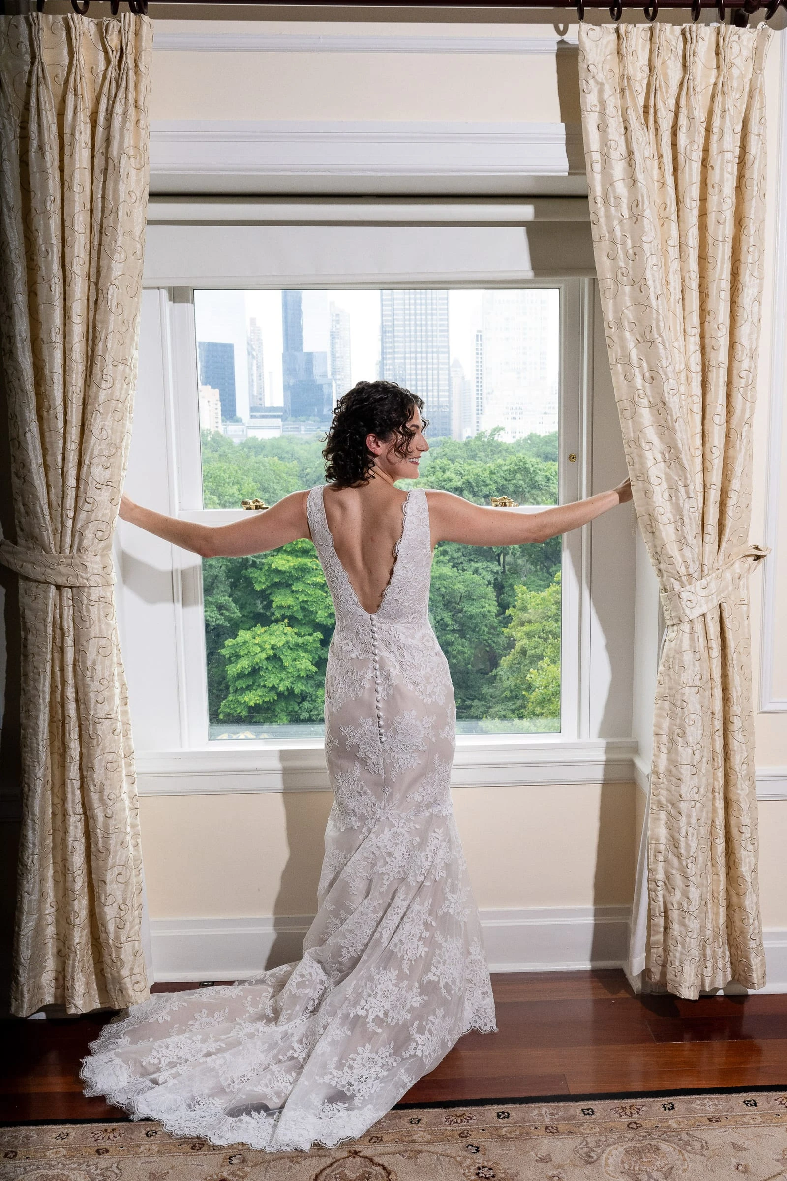 The bride drawing back the curtains at a window overlooking the park — Metropolitan Club, New York
