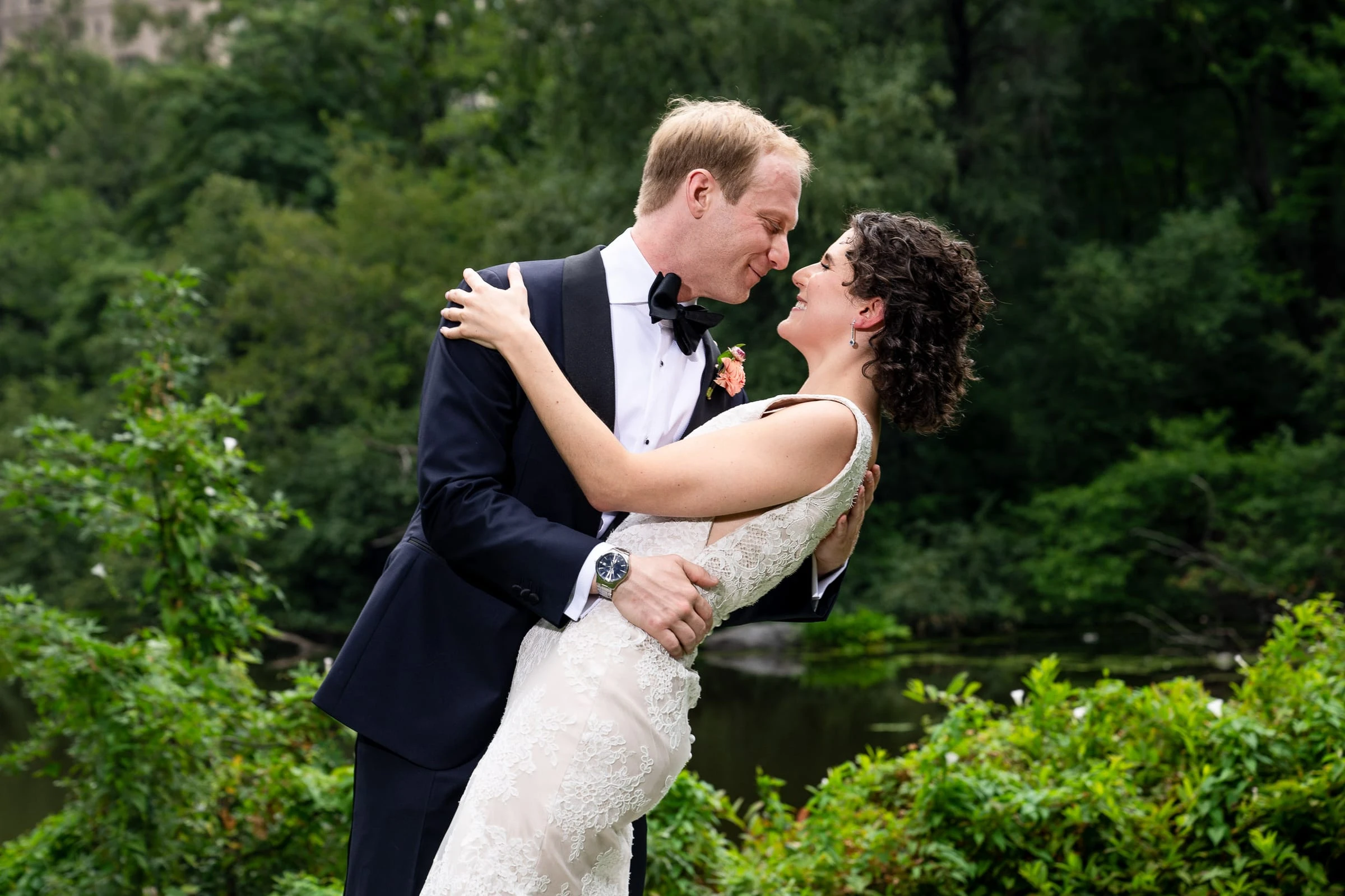 The groom lifting the bride in the park above the water — Metropolitan Club, New York