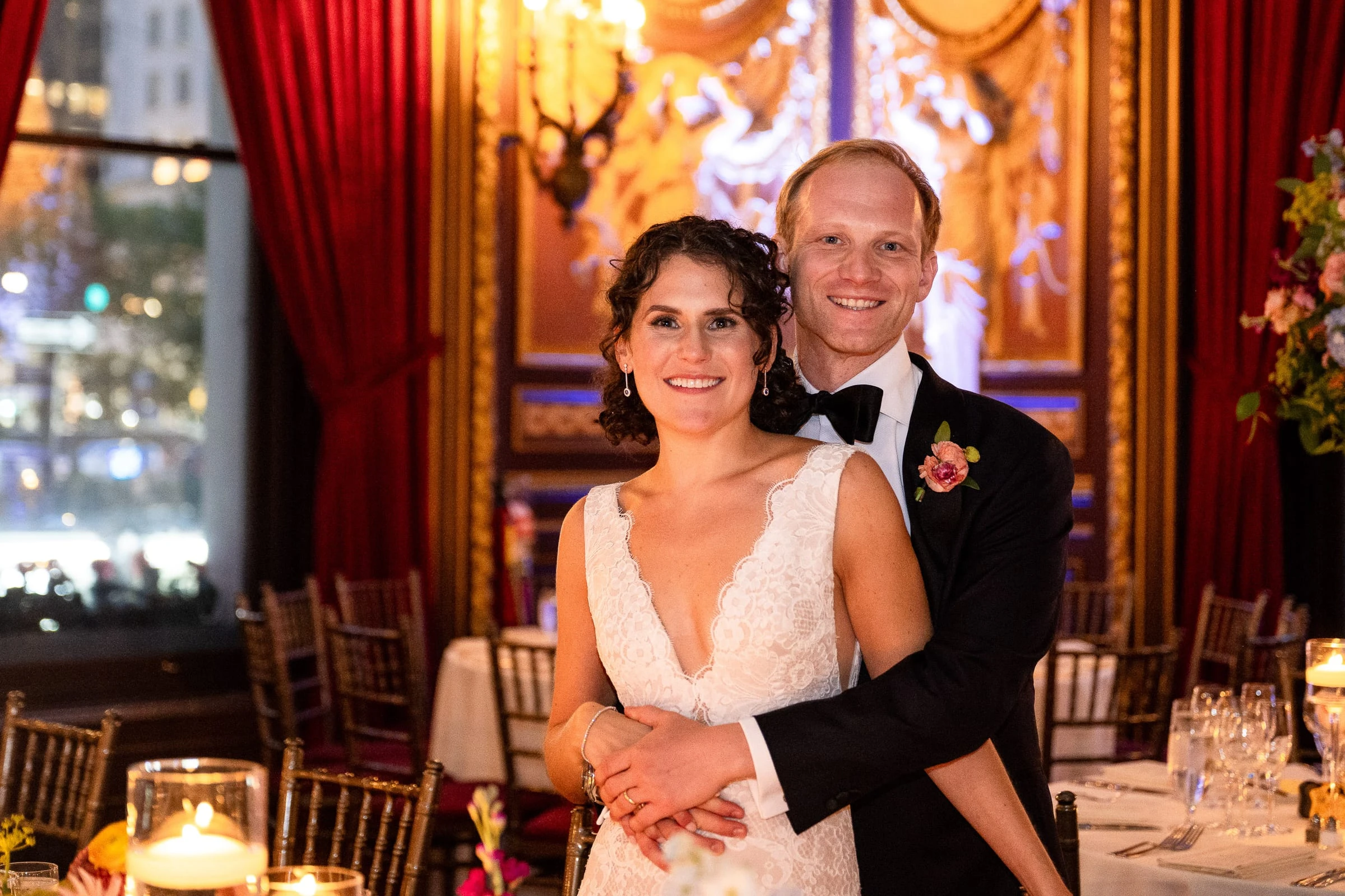 The bride and groom embracing and smiling in the candlelit ballroom — Metropolitan Club, New York