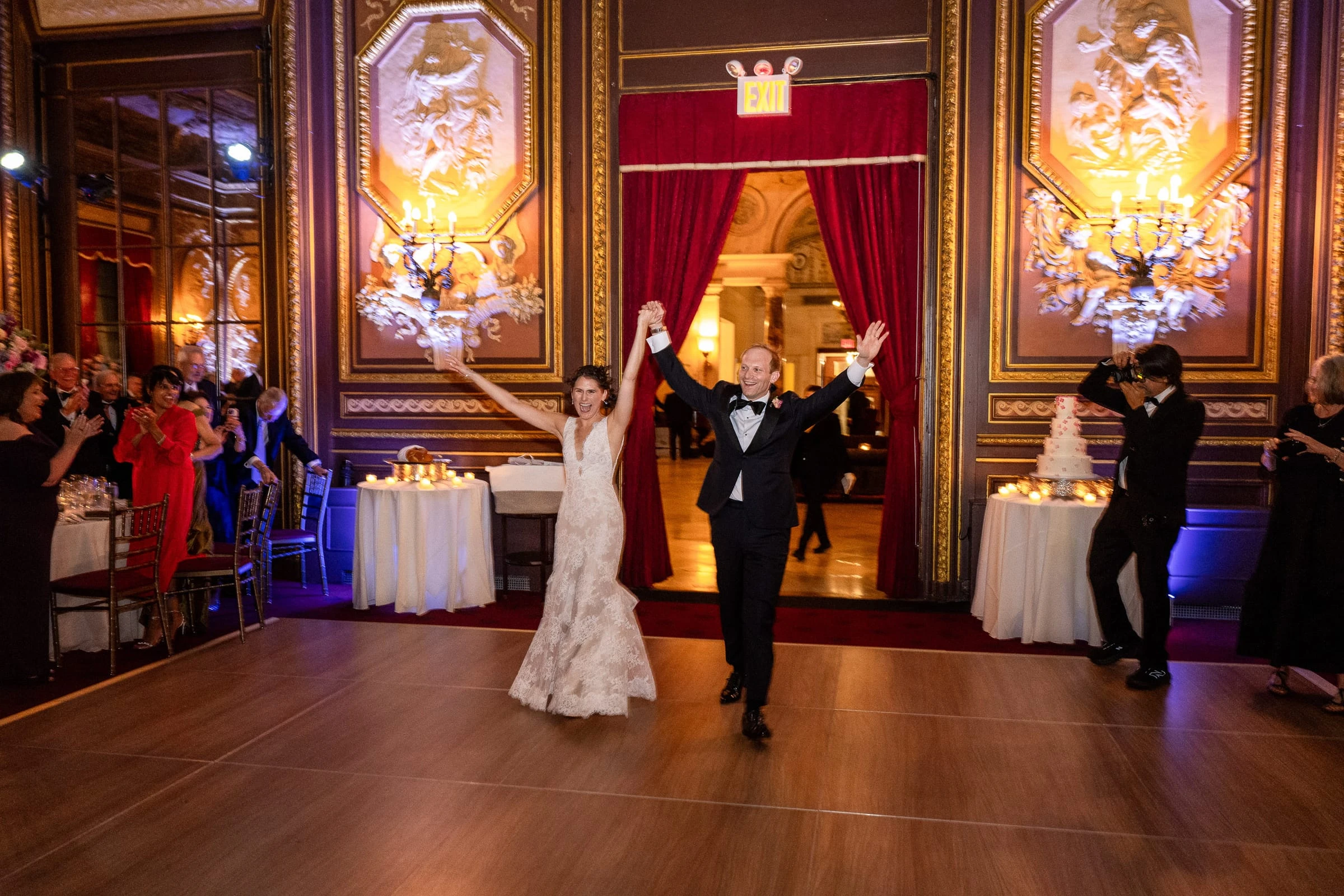 The bride and groom raising their arms as they enter the dance floor — Metropolitan Club, New York