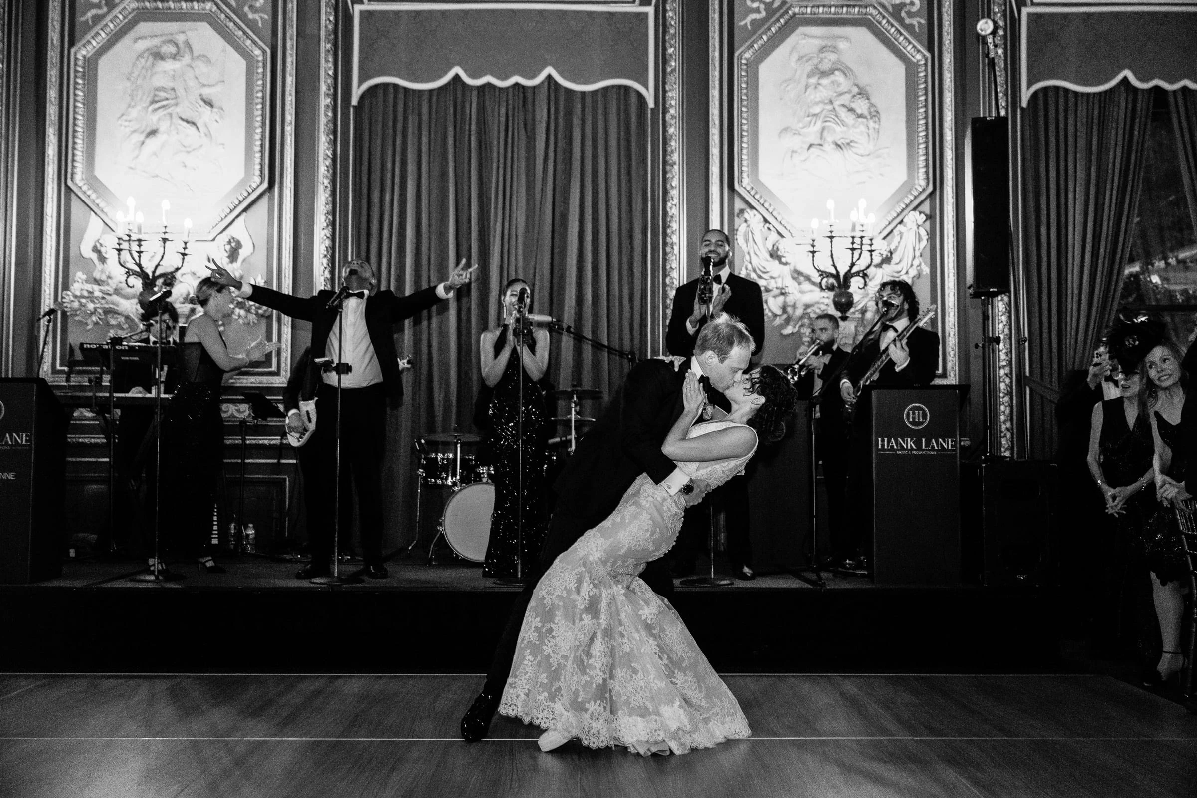 The groom dipping the bride in front of the band, in black and white — Metropolitan Club, New York