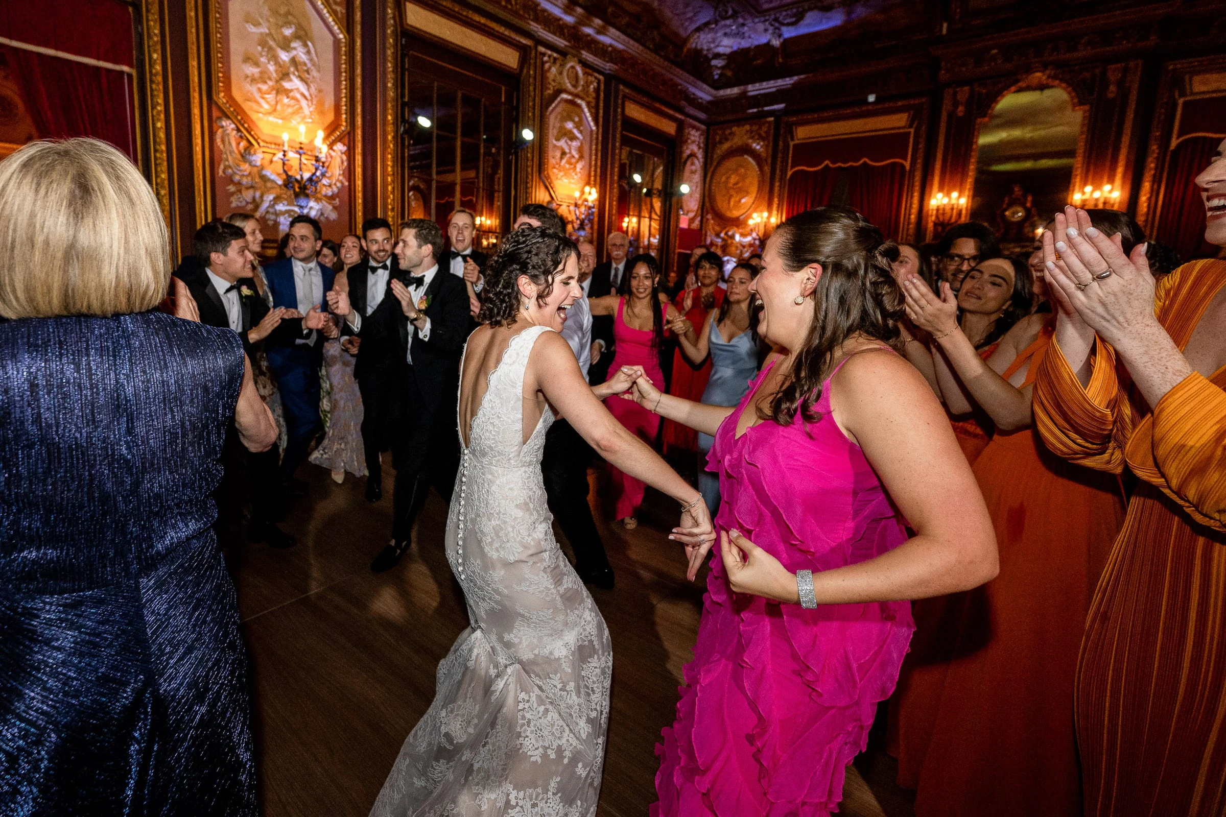 The bride dancing in a circle of friends on the crowded dance floor — Metropolitan Club, New York