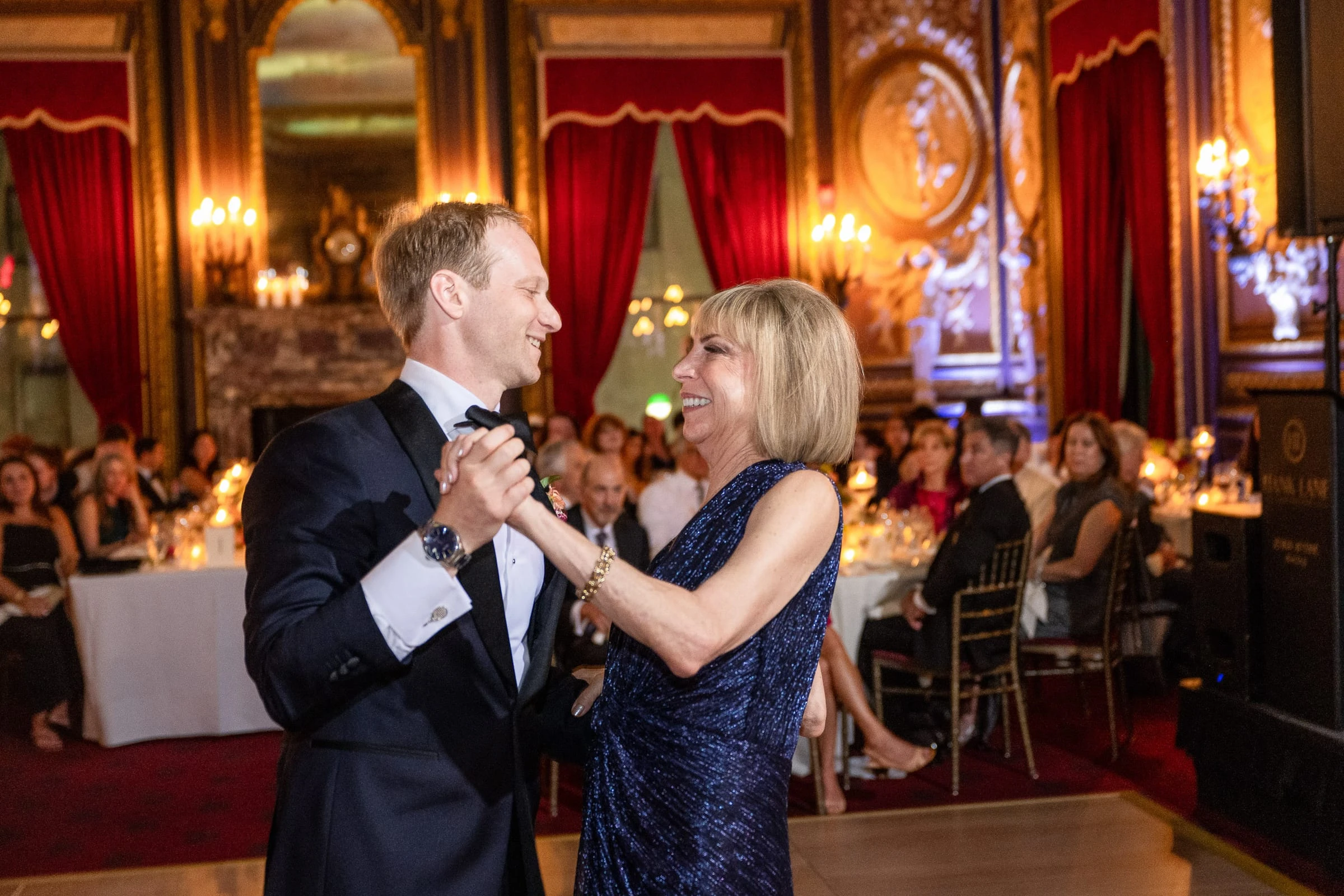 The groom dancing with a woman in a blue dress as guests watch — Metropolitan Club, New York