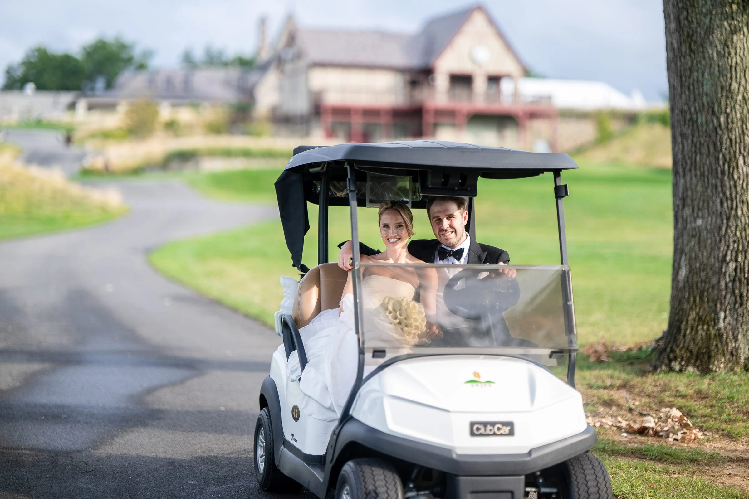 The couple driving a golf cart past the clubhouse — Mountain Ridge Country Club, West Caldwell