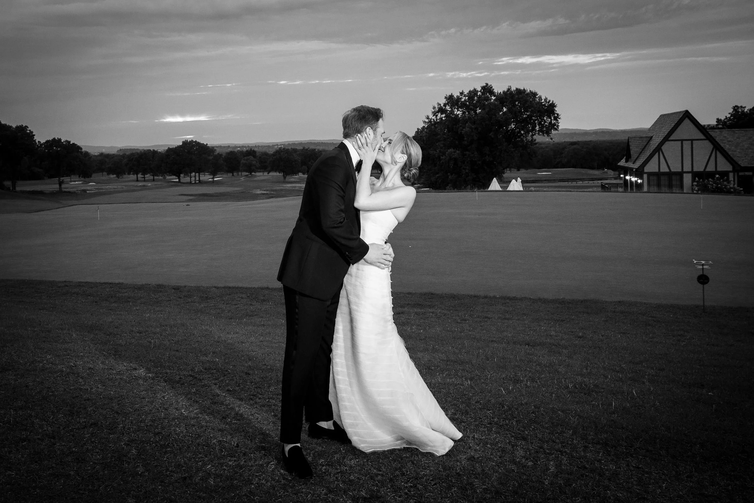 The couple kissing on the fairway with the clubhouse behind, in black and white — Mountain Ridge Country Club, West Caldwell