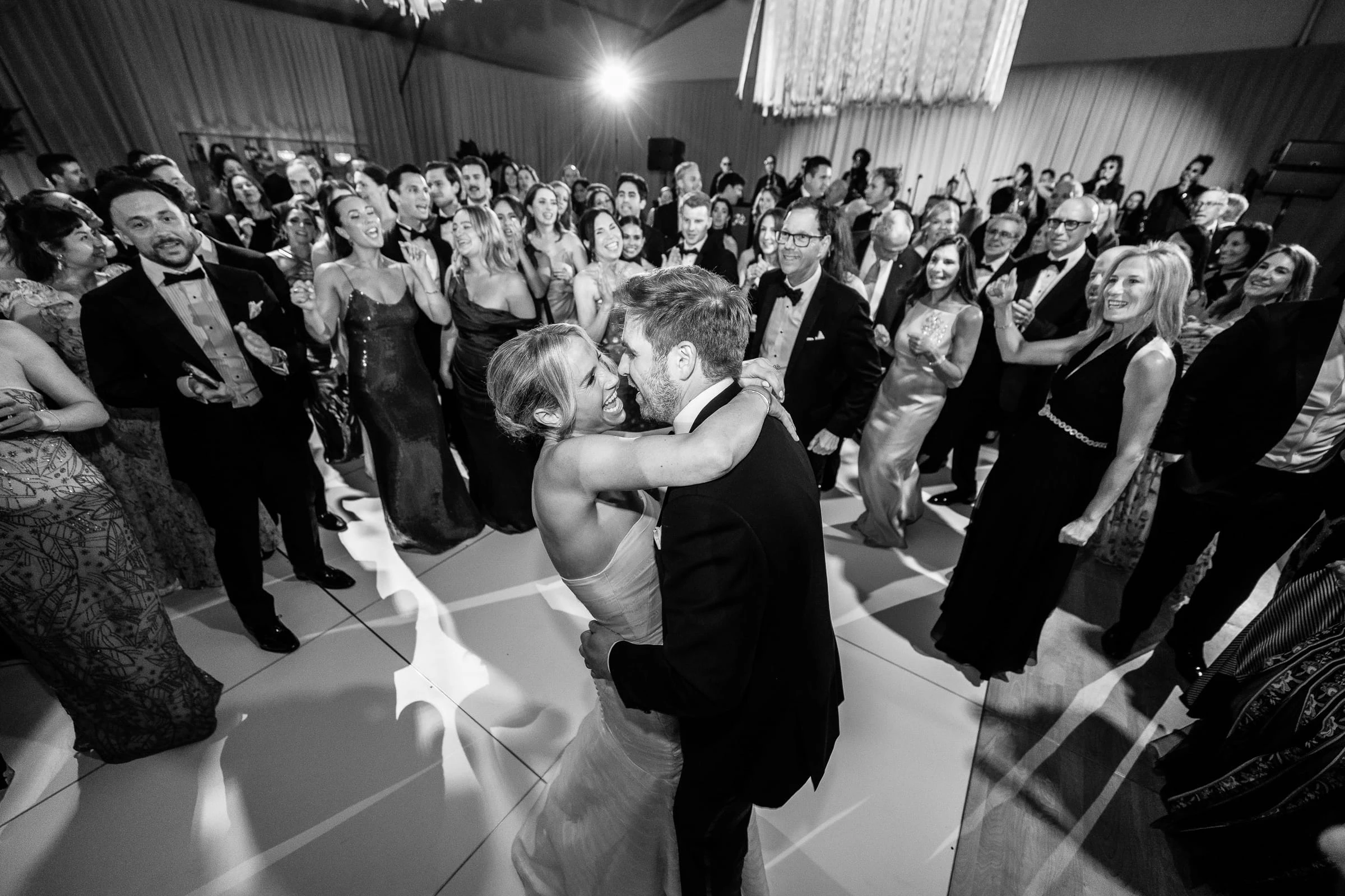 The bride and groom embracing in the middle of a crowded dance floor, in black and white — Mountain Ridge Country Club, West Caldwell