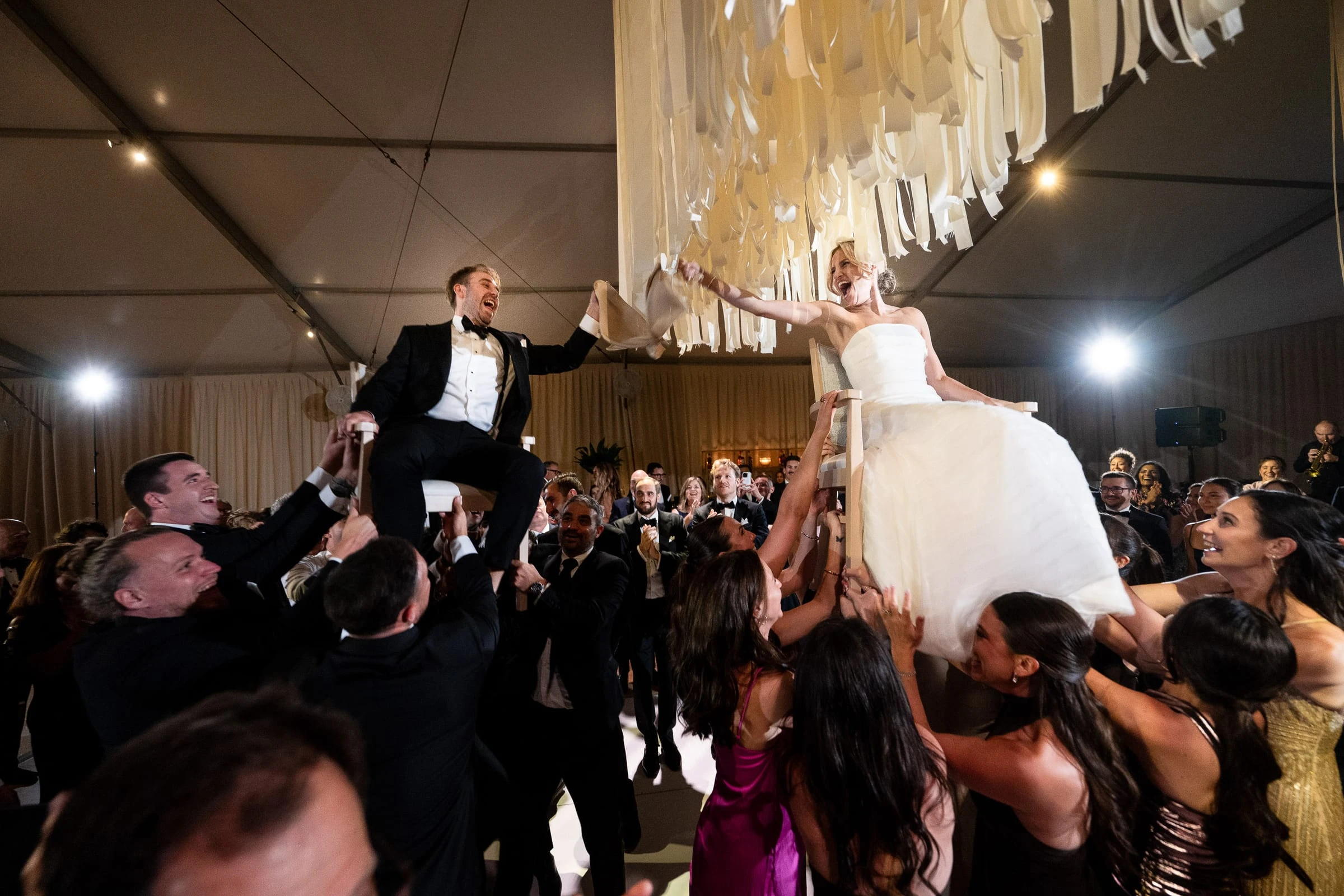 The bride and groom lifted on chairs above the crowd during the hora — Mountain Ridge Country Club, West Caldwell