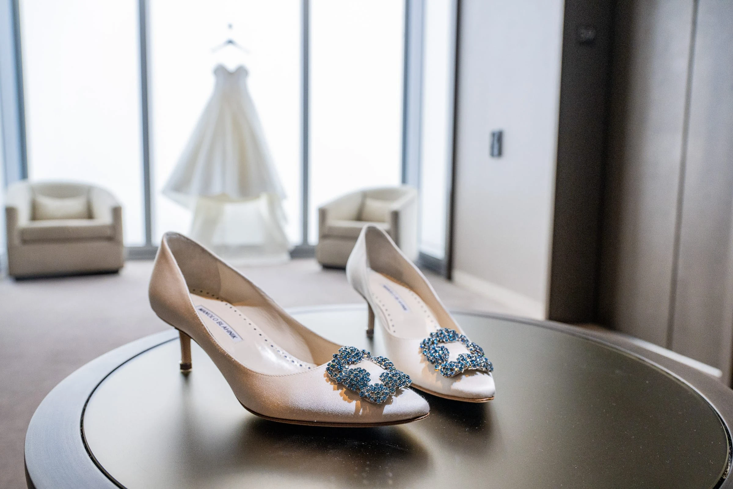 The bride's shoes on a table with her gown hanging in the window behind — Philadelphia Museum of Art, Philadelphia