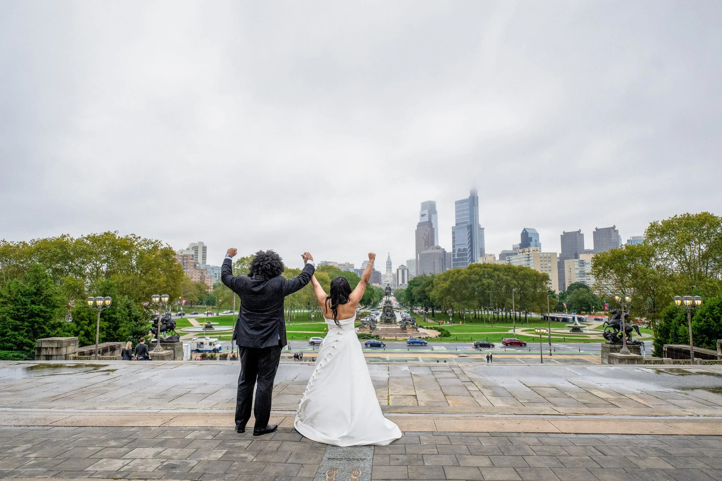 Arms raised on the museum steps facing the city skyline — Philadelphia Museum of Art, Philadelphia