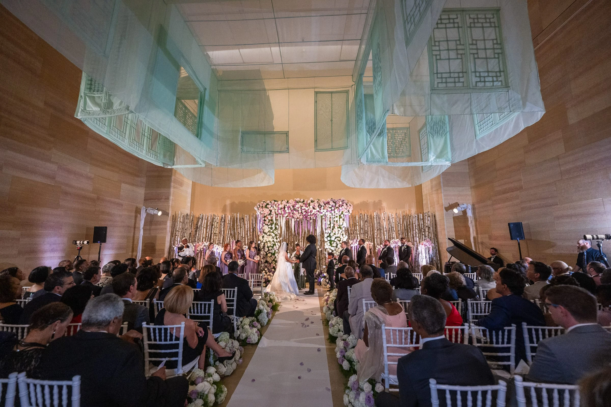The full room of guests during the ceremony beneath the hanging glass — Philadelphia Museum of Art, Philadelphia