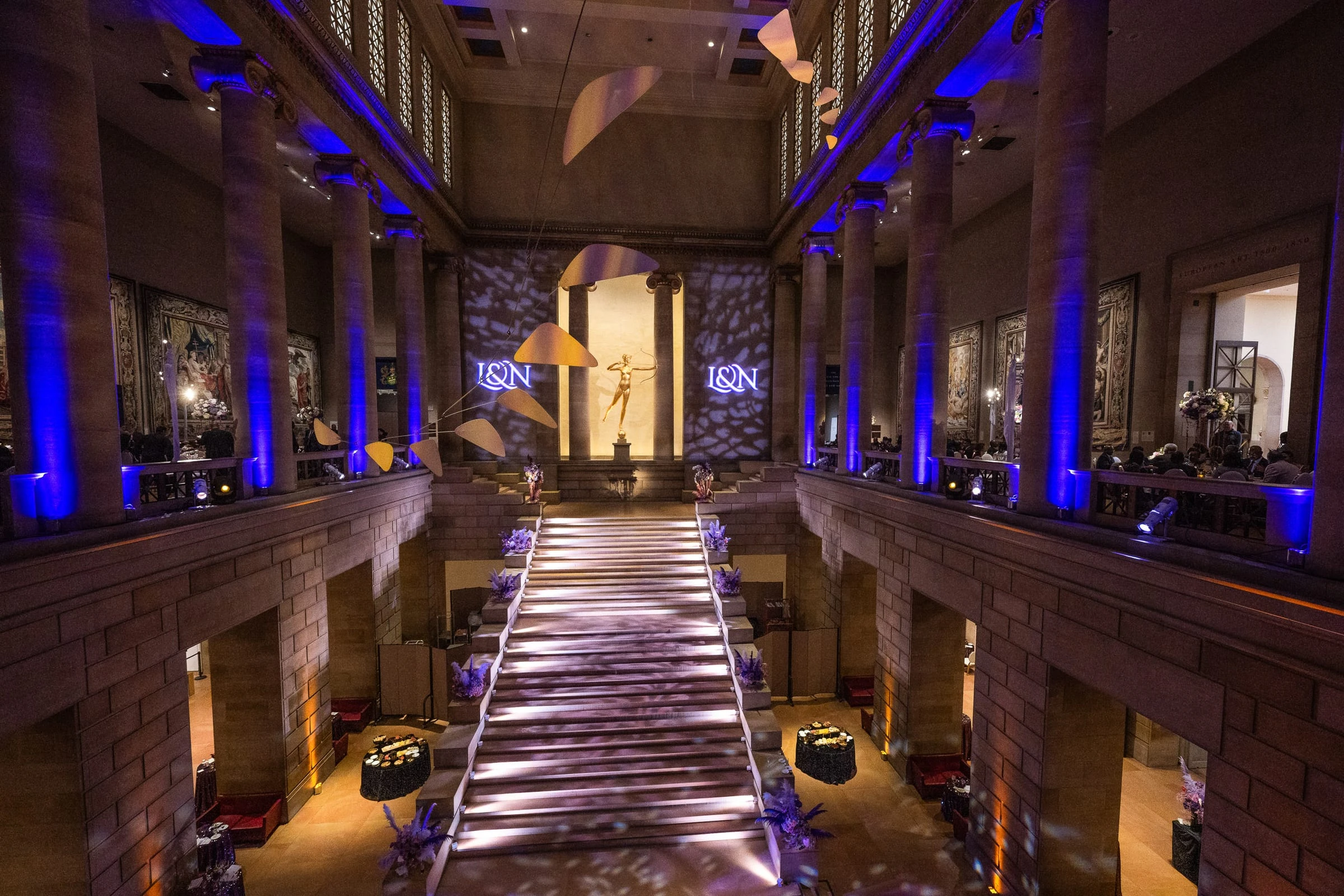 The great hall lit blue with the monogram projected on the walls — Philadelphia Museum of Art, Philadelphia