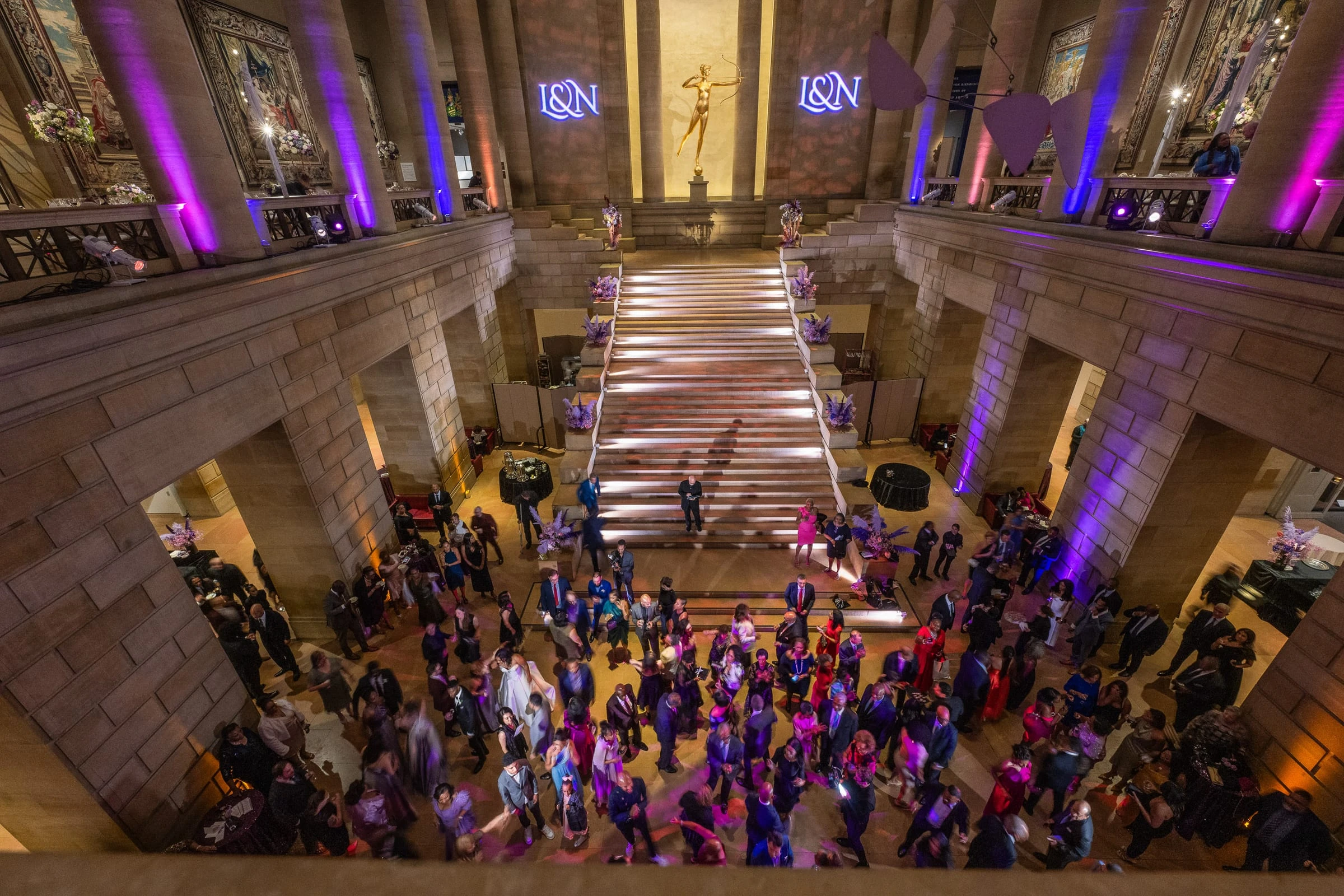 The museum's great stair hall from above, a dance floor full of guests under the monogram lights — Philadelphia Museum of Art, Philadelphia