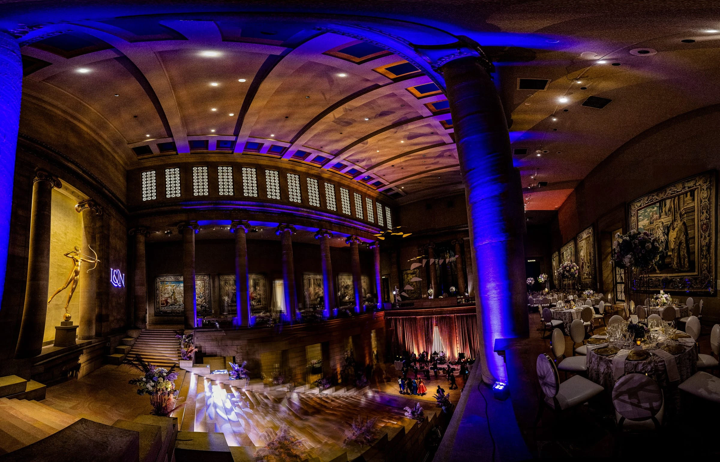 The museum's vaulted reception hall in blue light, the dinner tables set below — Philadelphia Museum of Art, Philadelphia