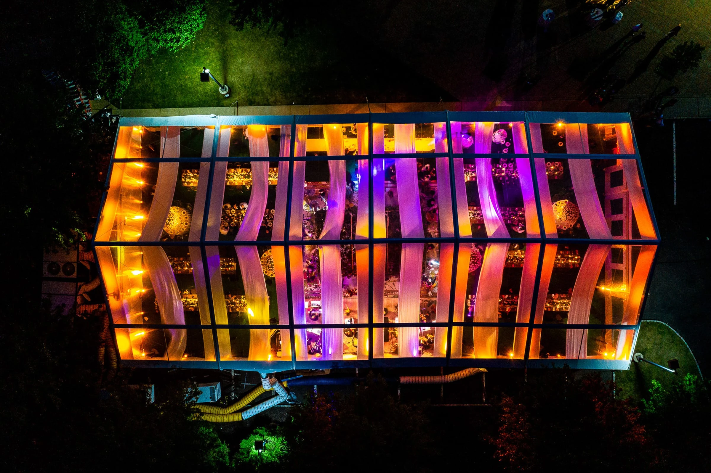 A glowing reception tent seen from directly above at night